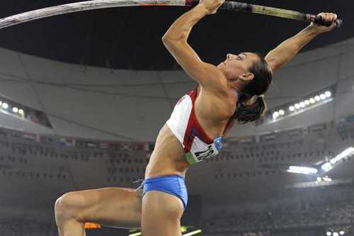 woman pole vaulting for Russia in red white and blue uniform during the take off phase